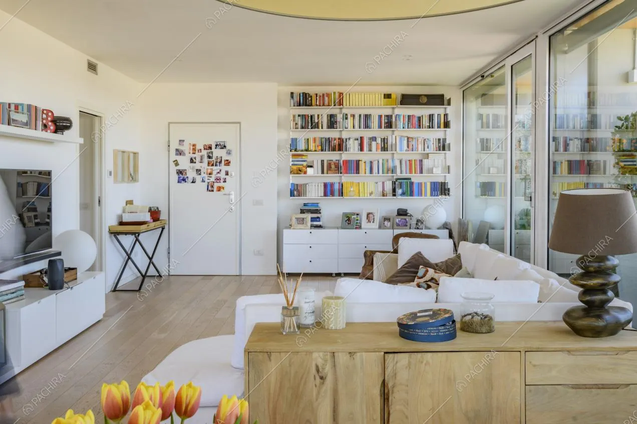 Angolo salotto con libreria, divano e mobile in legno