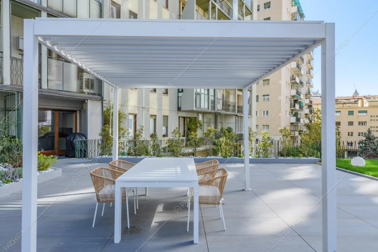 Gazebo bianco con tavolo da pranzo e sedie sulla terrazza