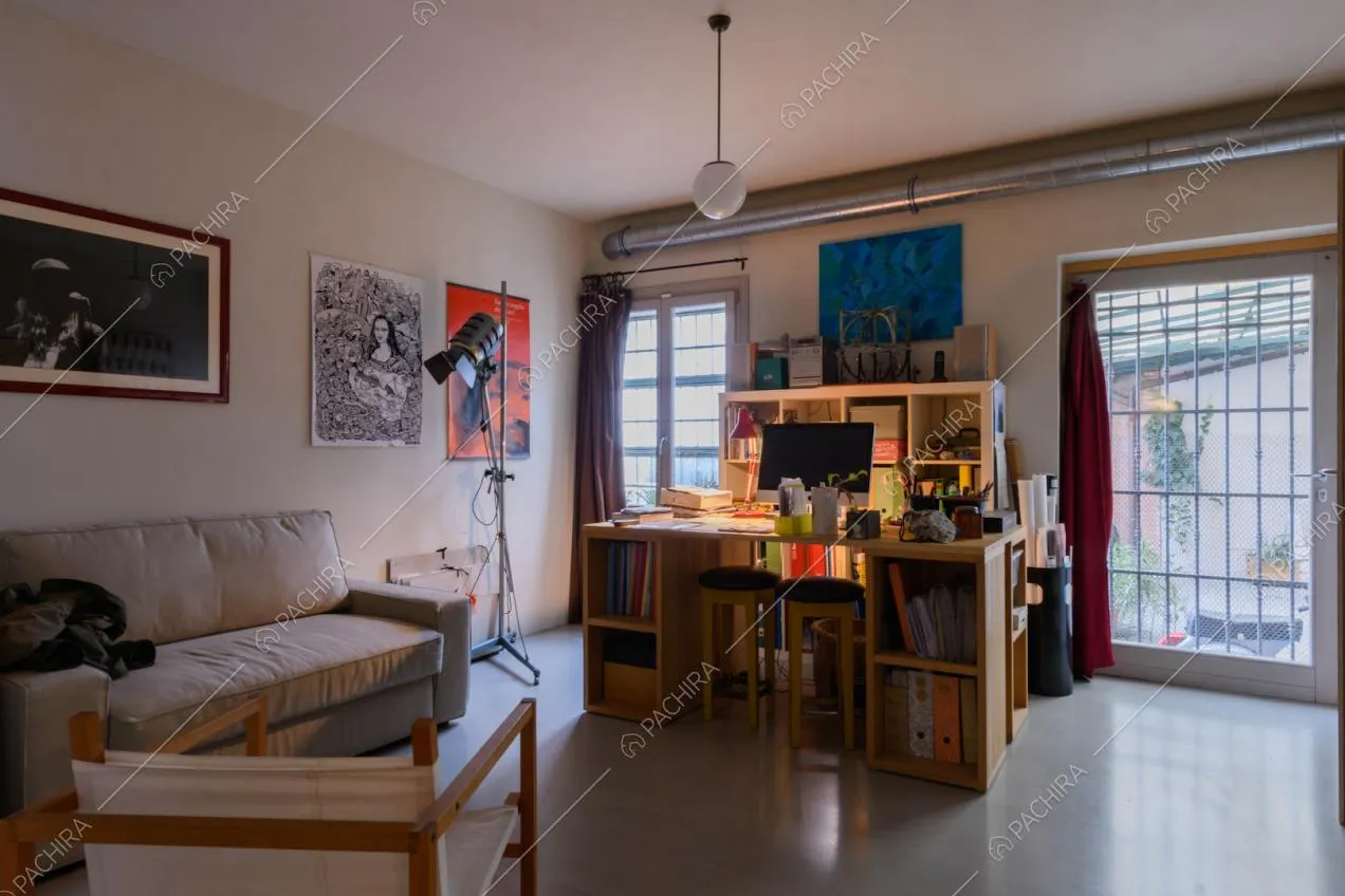 Studio con porta-finestra per accedere al giardino e pavimento in resina