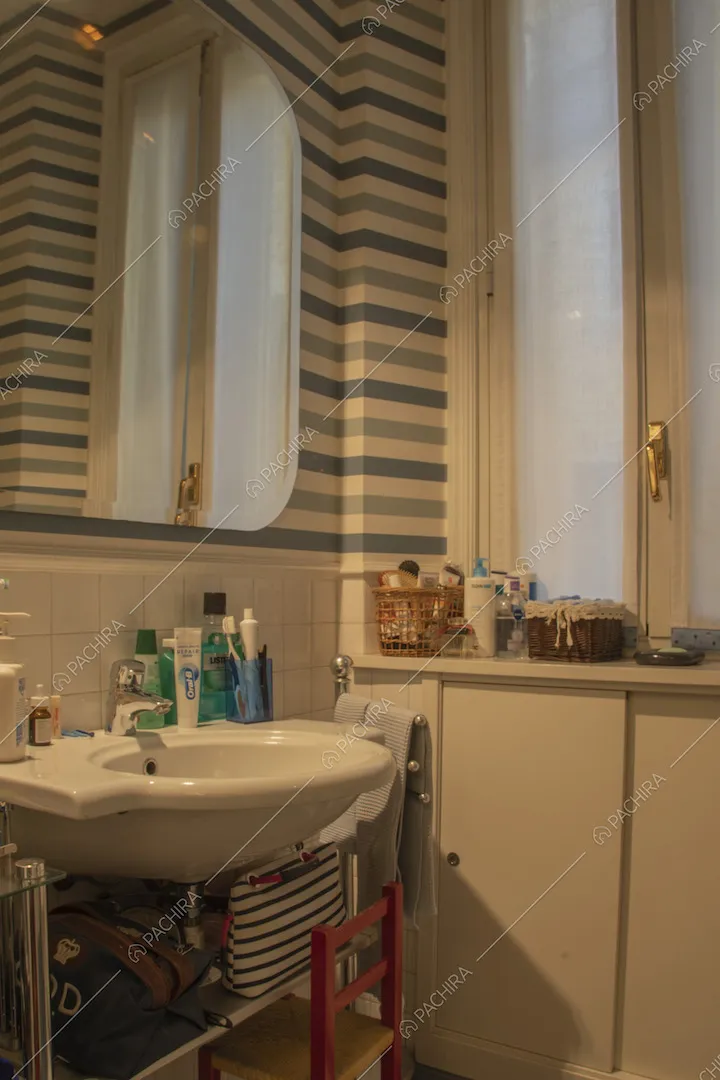 Parete a righe, specchio e lavabo nel bagno