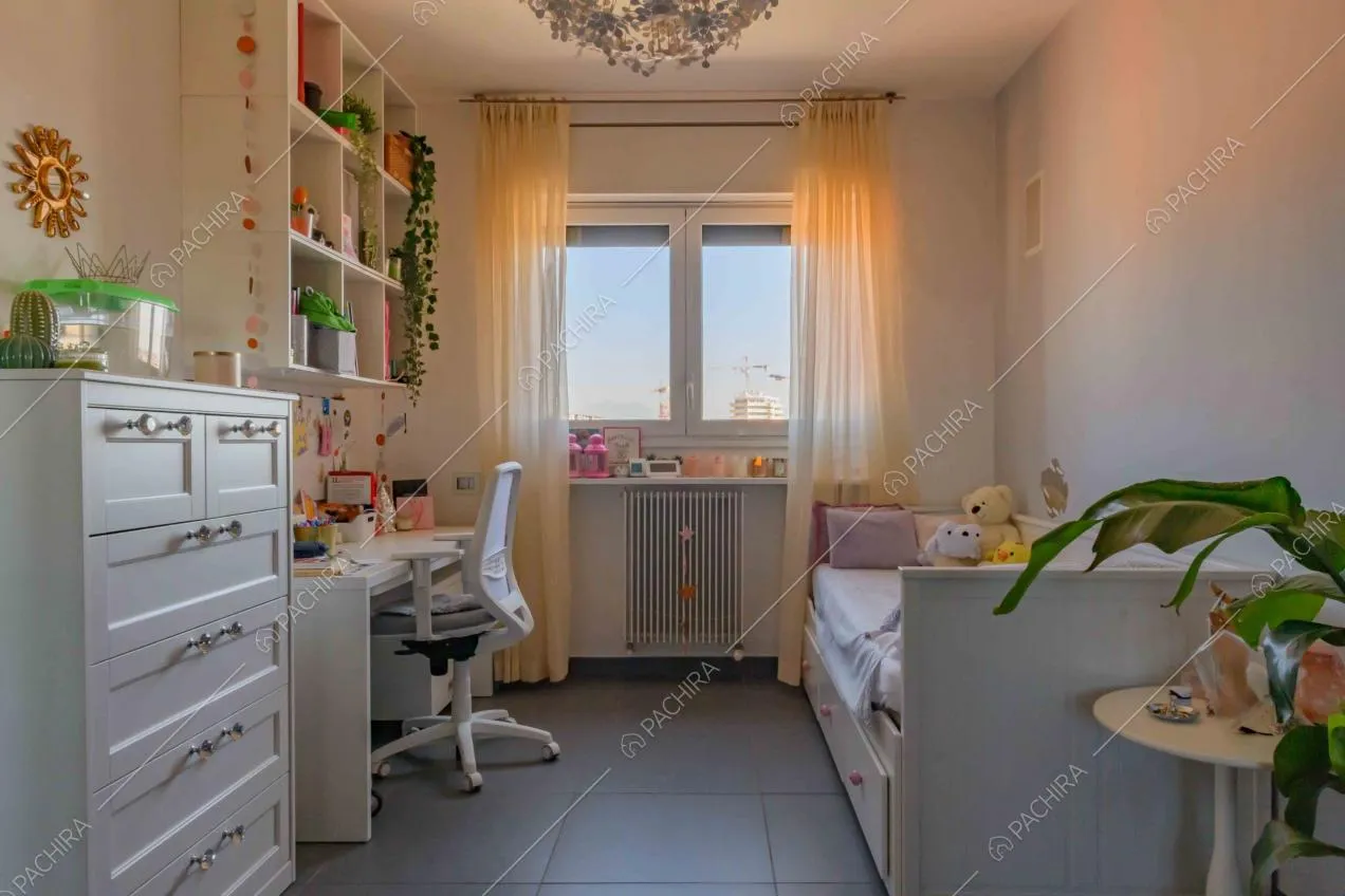 Camera da letto da bambini con scrivania bianca, vista sullo skyline e pavimento grigio