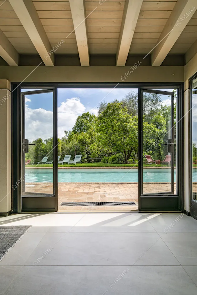 Porta finestra con scorcio sul giardino con piscina