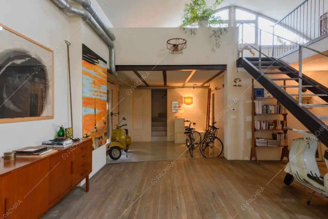 Pavimento in parquet nella zona living con mobili di design e vista sulle scale