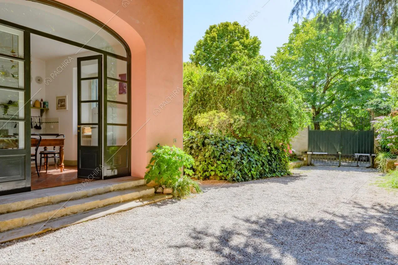 Dal giardino con ciottoli vista sulla cucina della location tramite le porte-finestre