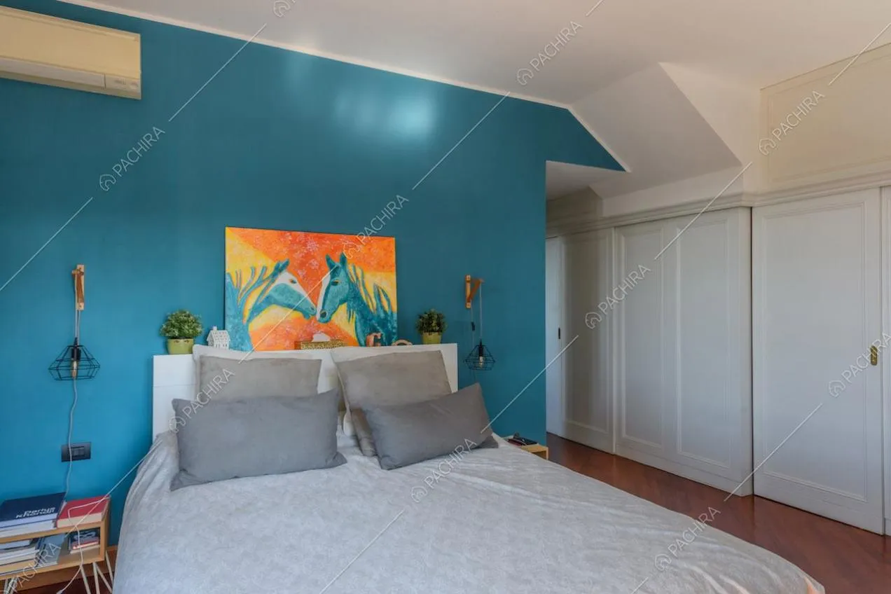 Parete azzurra nella camera da letto con armadi a muro