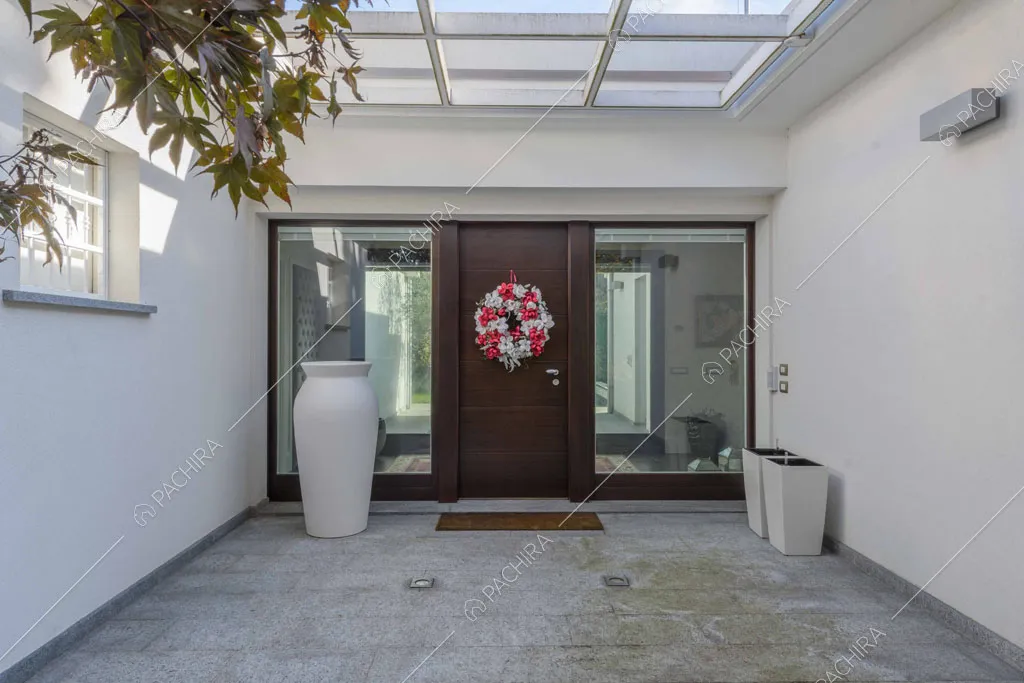 Portico moderno con lucernario, pareti bianche e grande vaso