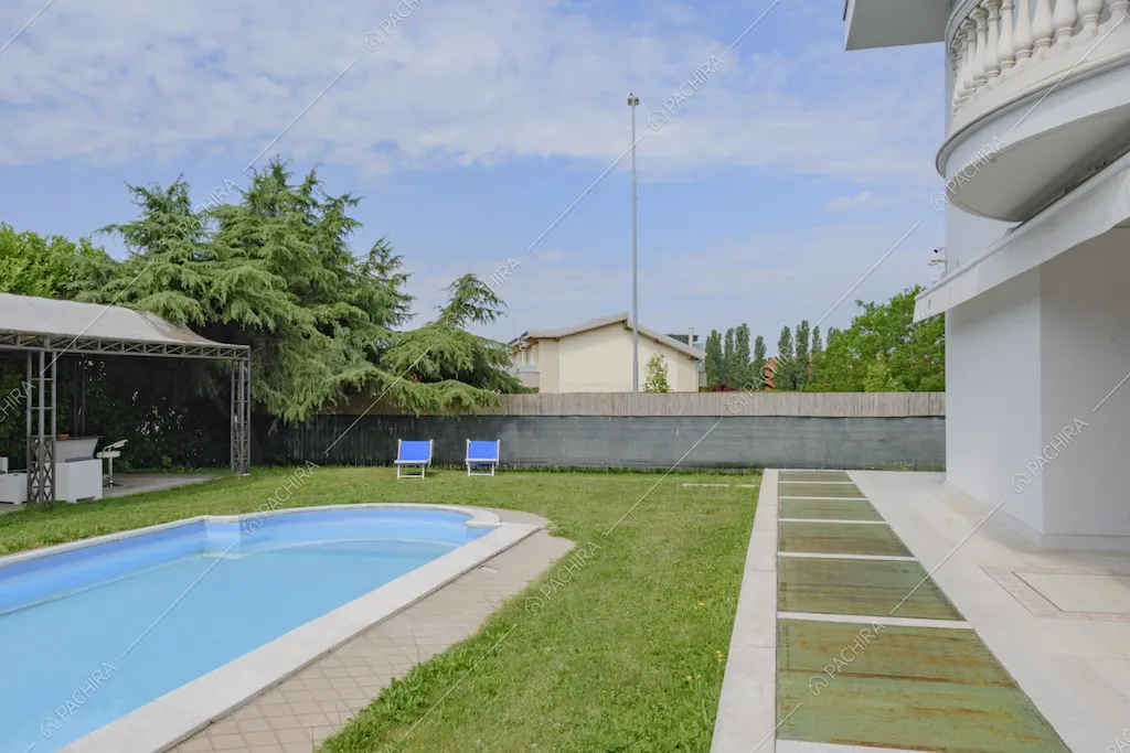 Sedie a sdraio blu nel prato che circonda la piscina