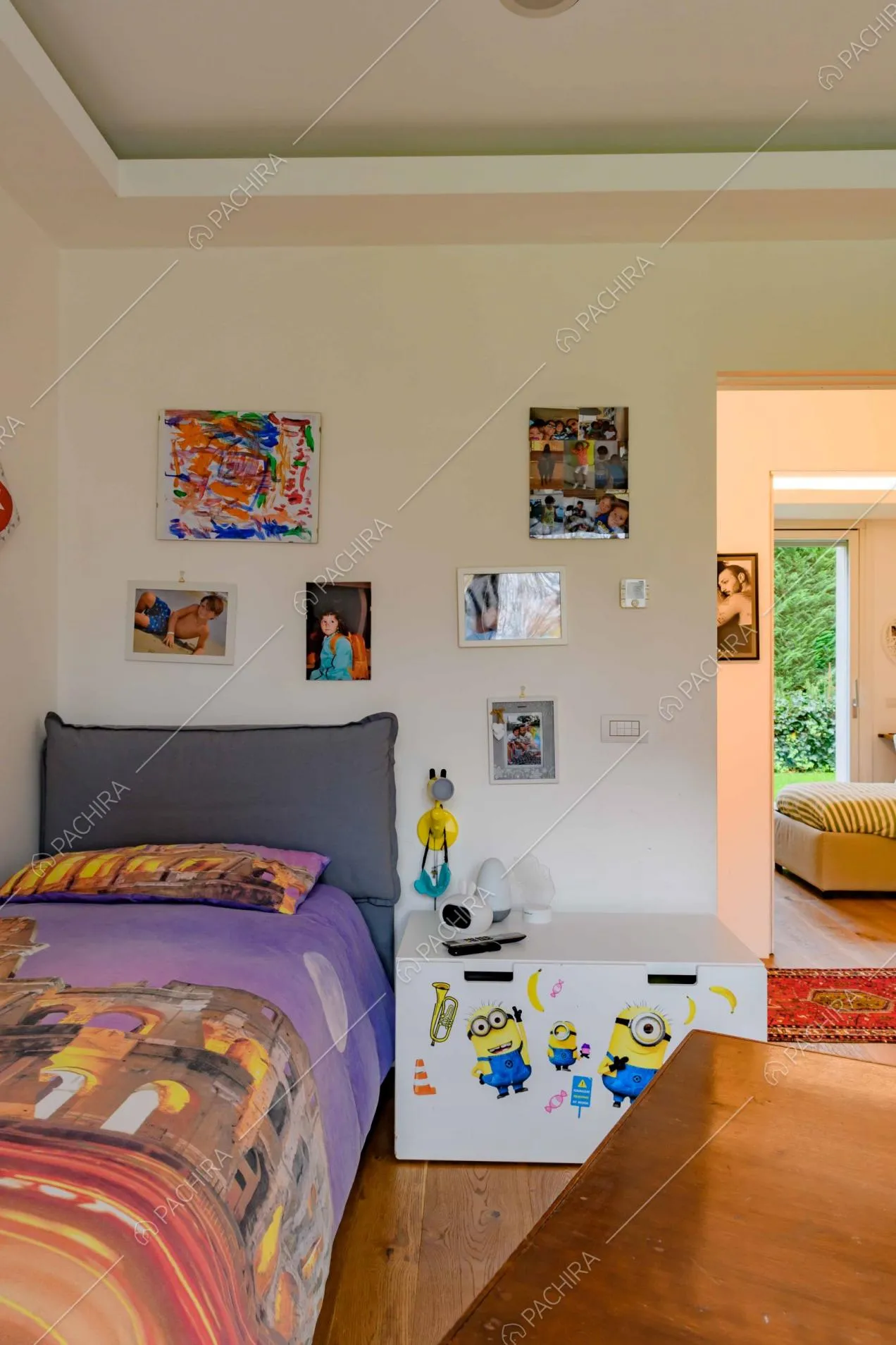 Camera da letto da bambini dalle pareti bianche e dal pavimento in parquet con vista sulla camera da letto matrimoniale
