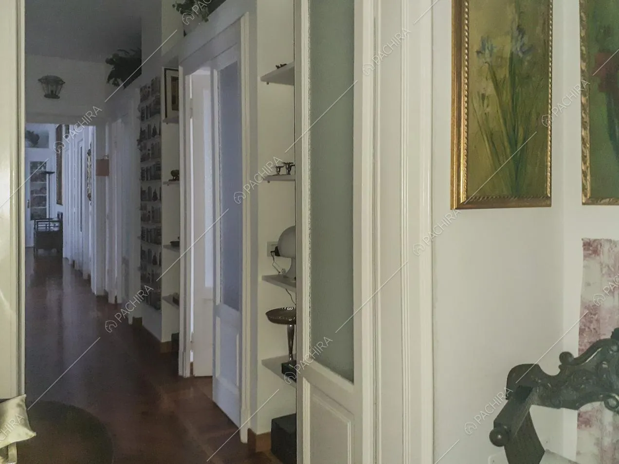 Corridoio con porte d'epoca e mensole con soprammobili