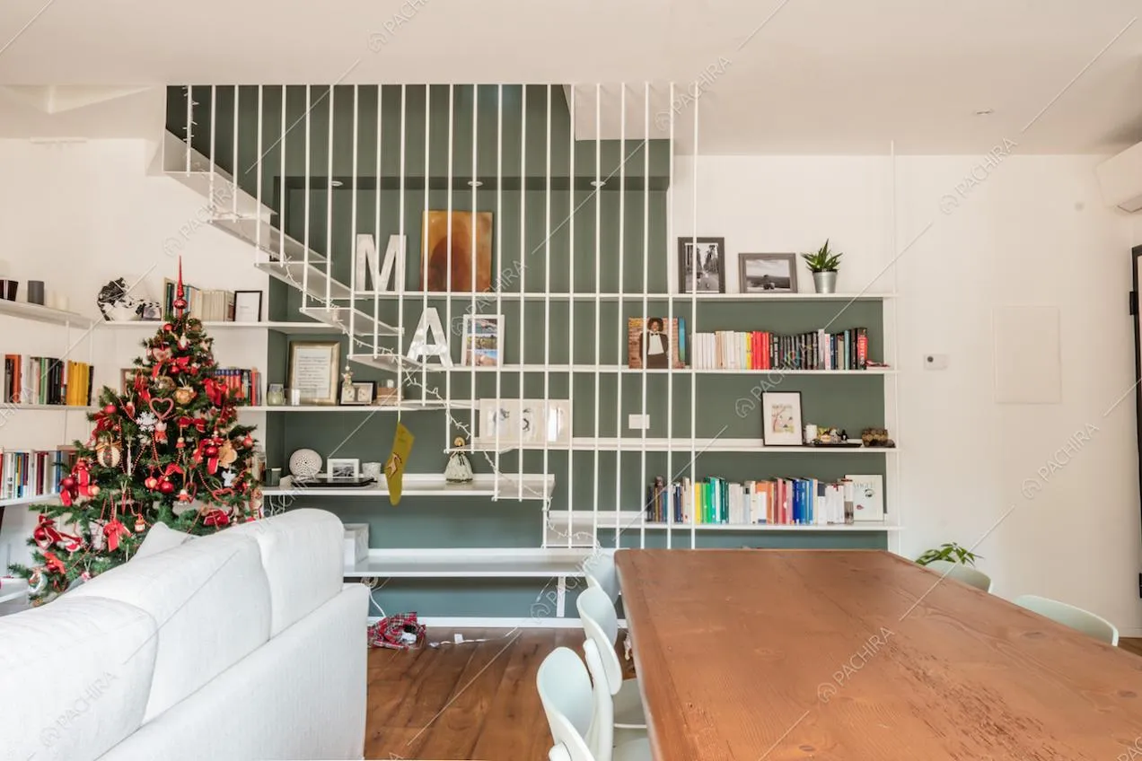 Tavolo in legno rettangolare con sedie bianche e libreria