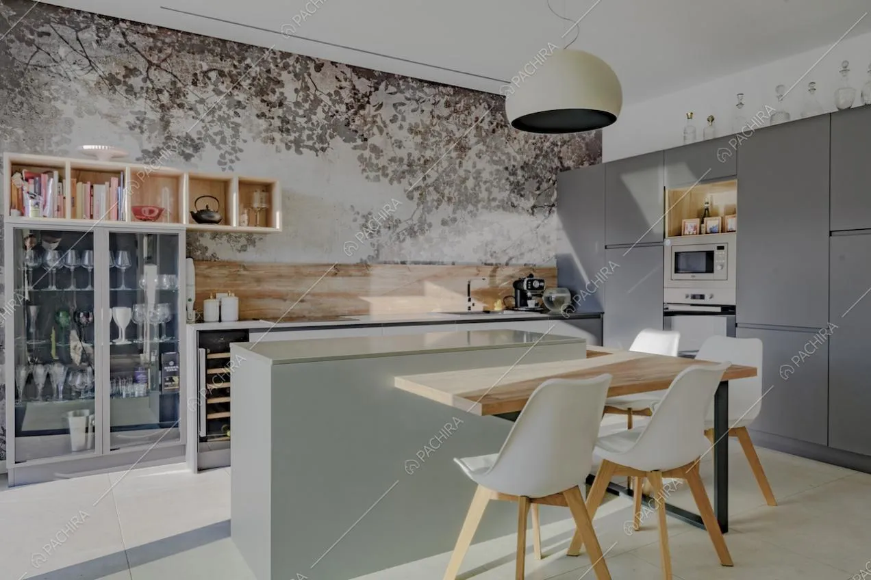 Cucina a isola nei toni del grigio e credenza con stoviglie