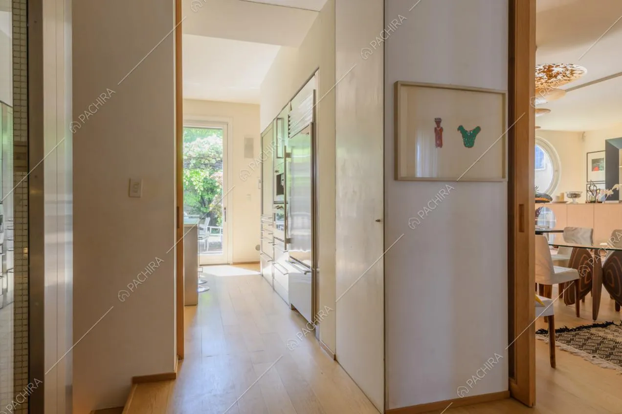Luminoso corridoio con pavimento in parquet e porta-finestra