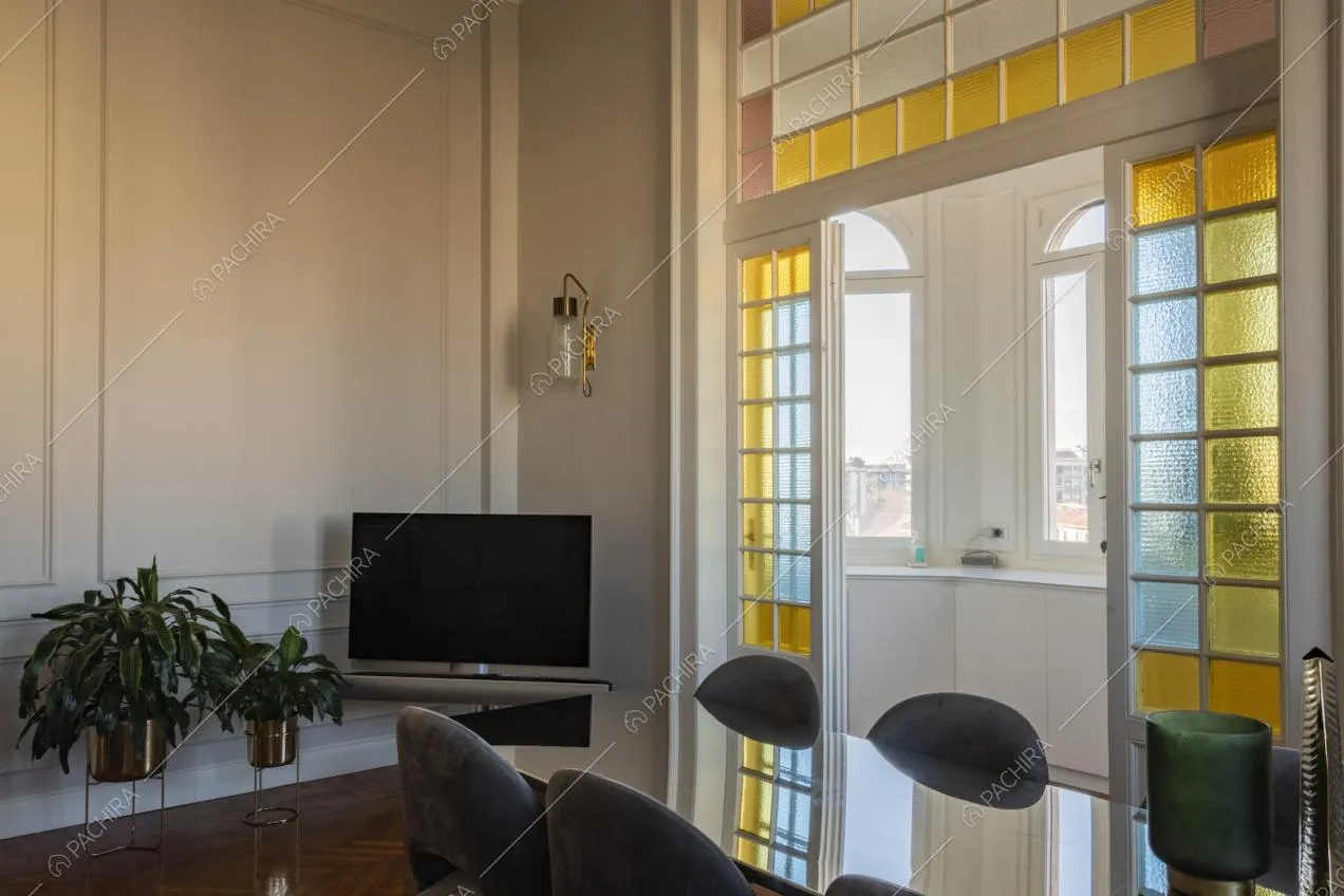 Tavolo da pranzo e vetrate colorate all'ingresso della cucina