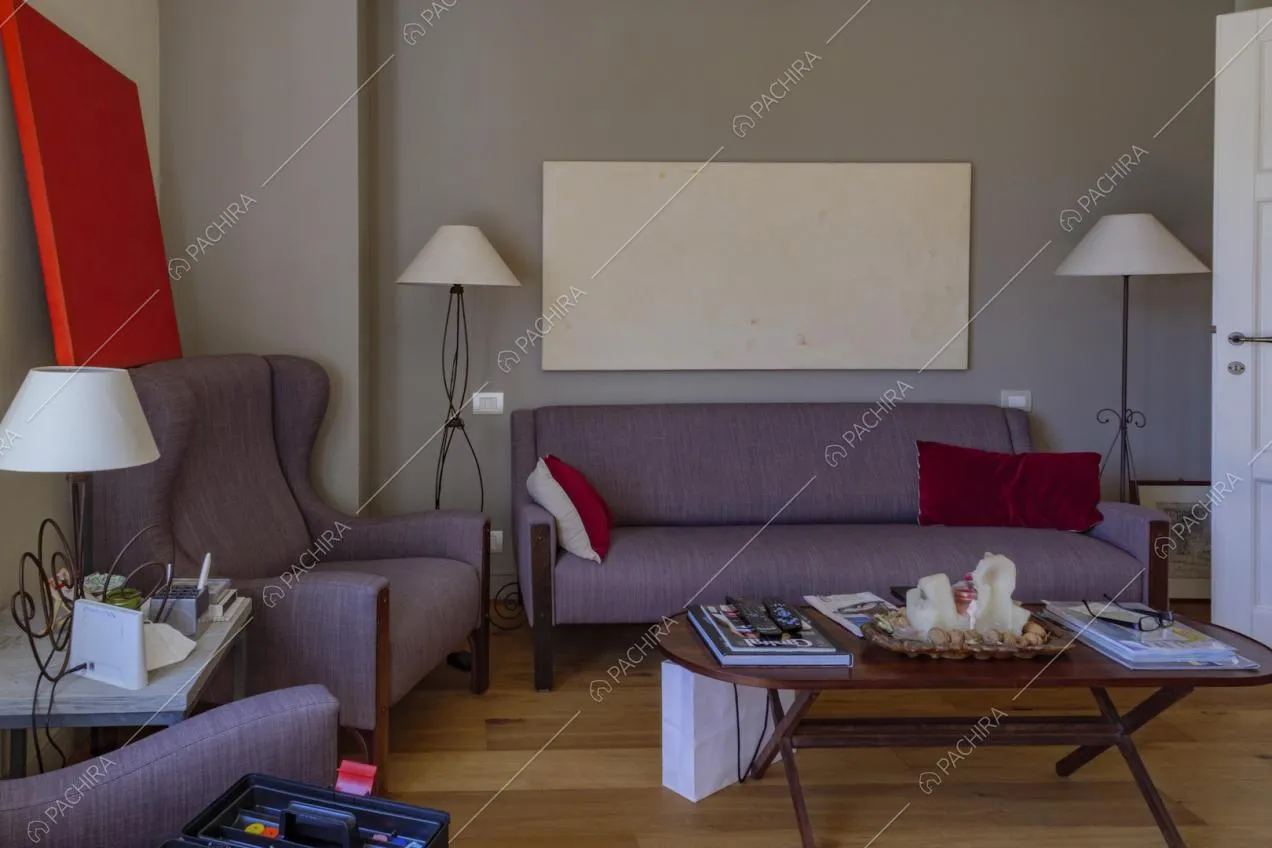 Divano e poltrone viola nel salotto con pavimento in parquet