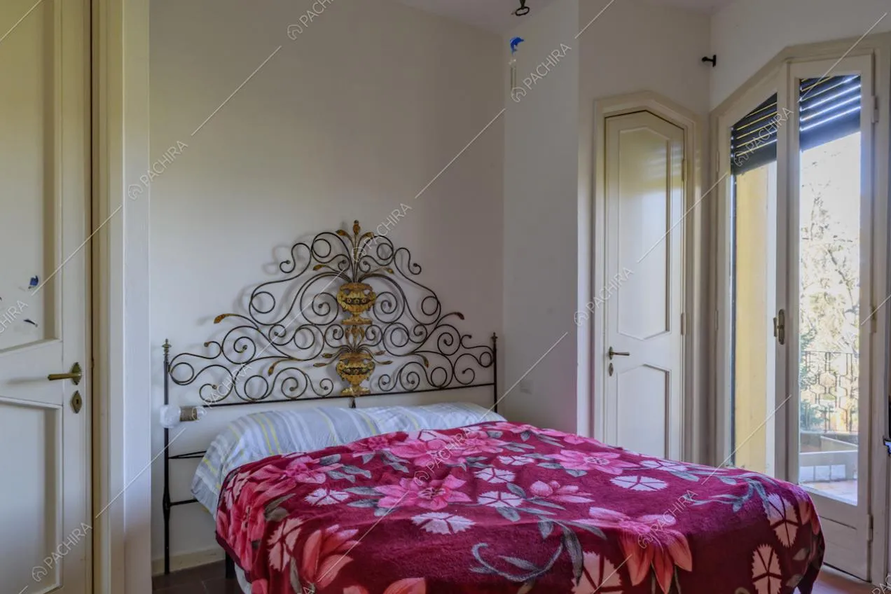 Camera da letto matrimoniale dalle pareti bianche e con accesso al balcone
