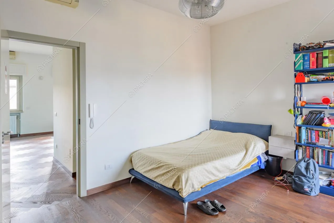 Pavimento in parquet nella luminosa camera da letto con pareti bianche
