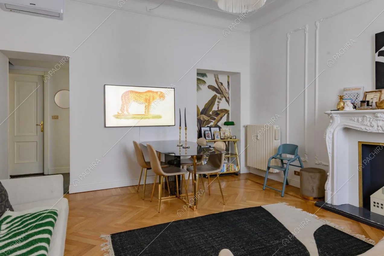 Tavolo da pranzo nel salotto con boiserie su pareti e soffitto e camino