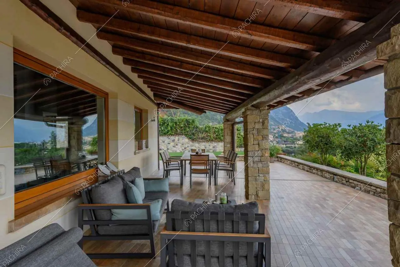Poltrone, divani e tavolo da pranzo nella veranda con vista sul lago