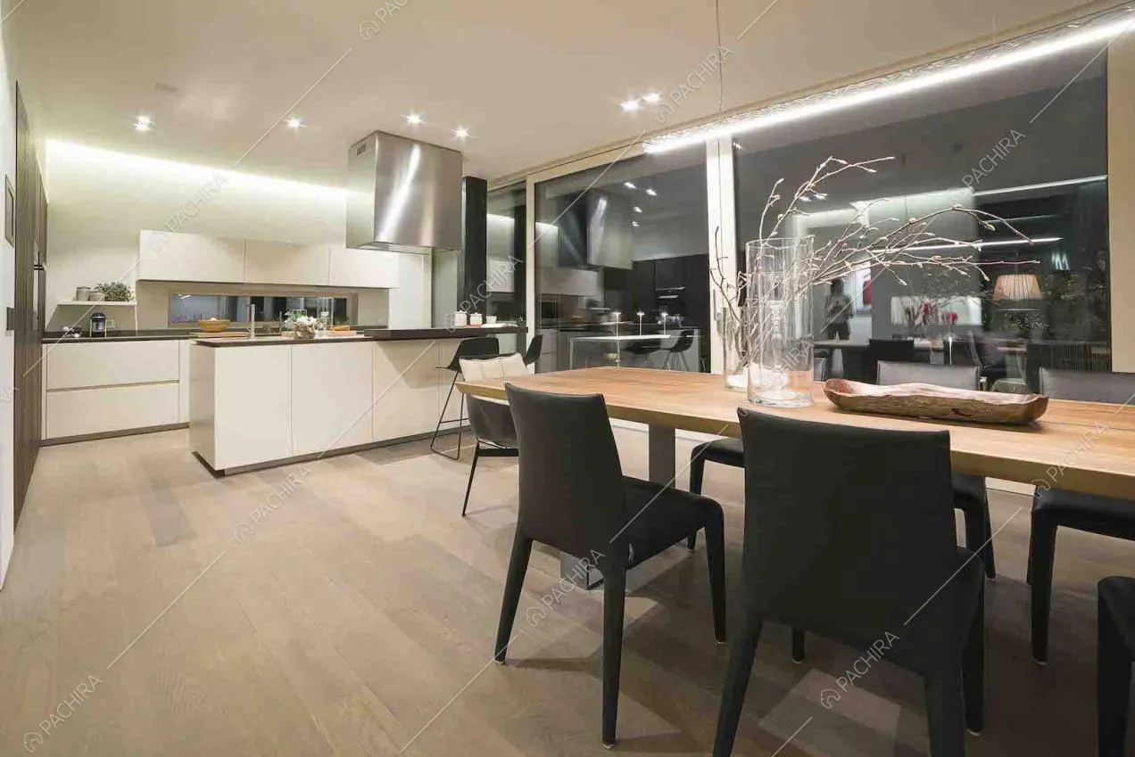 Soggiorno con cucina bianca a vista e pavimento in parquet