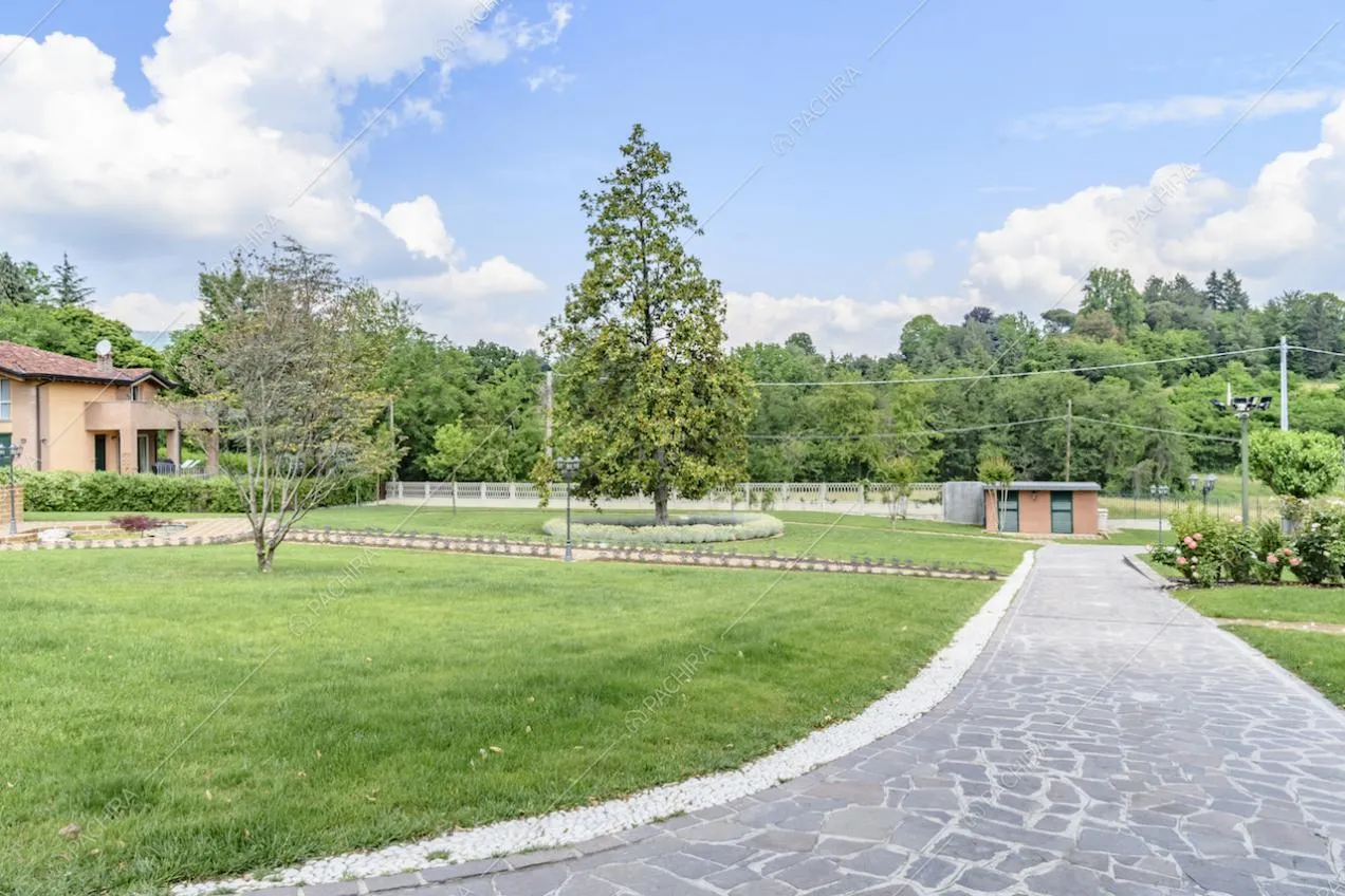 Vialetto per le auto in lastre di pietra nel giardino della location con vista sul capanno