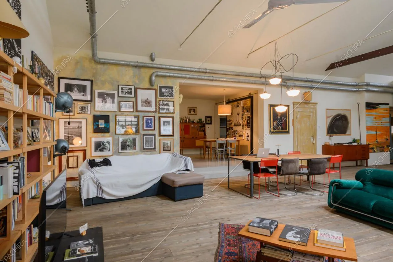 Pavimento in parquet, libreria, parete délabré e divani colorati nel salotto