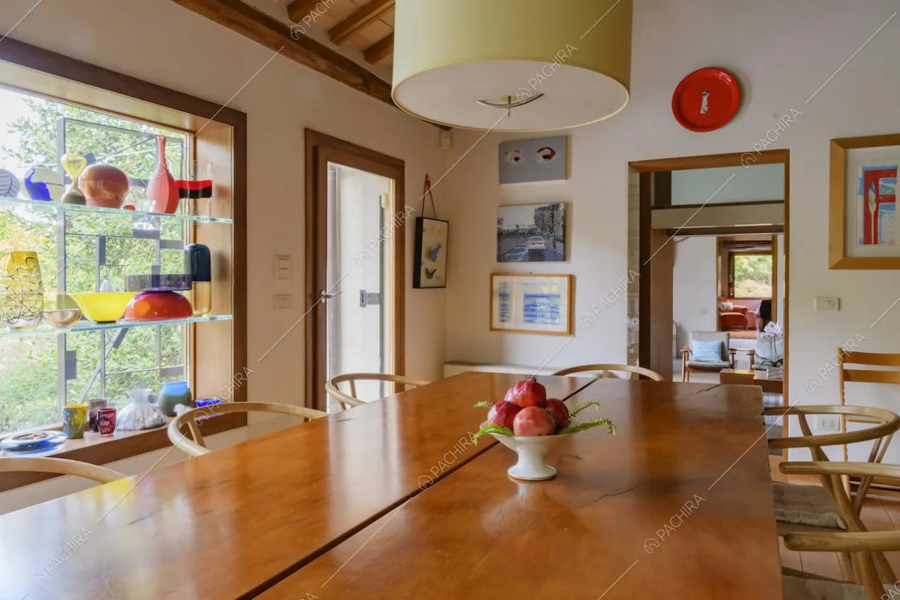 Tavolo da pranzo in legno con sedie e soprammobili colorati