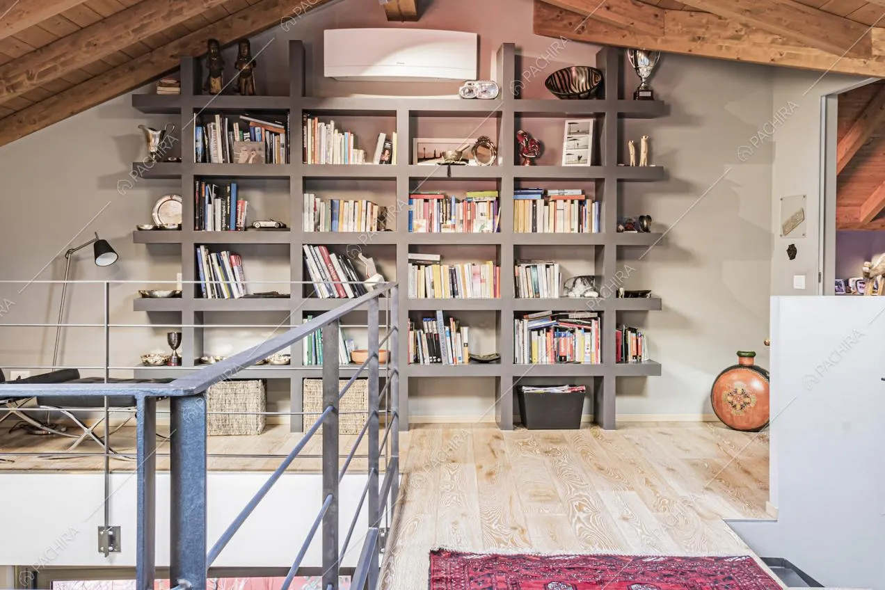 Pavimento in legno chiaro e libreria color grigio