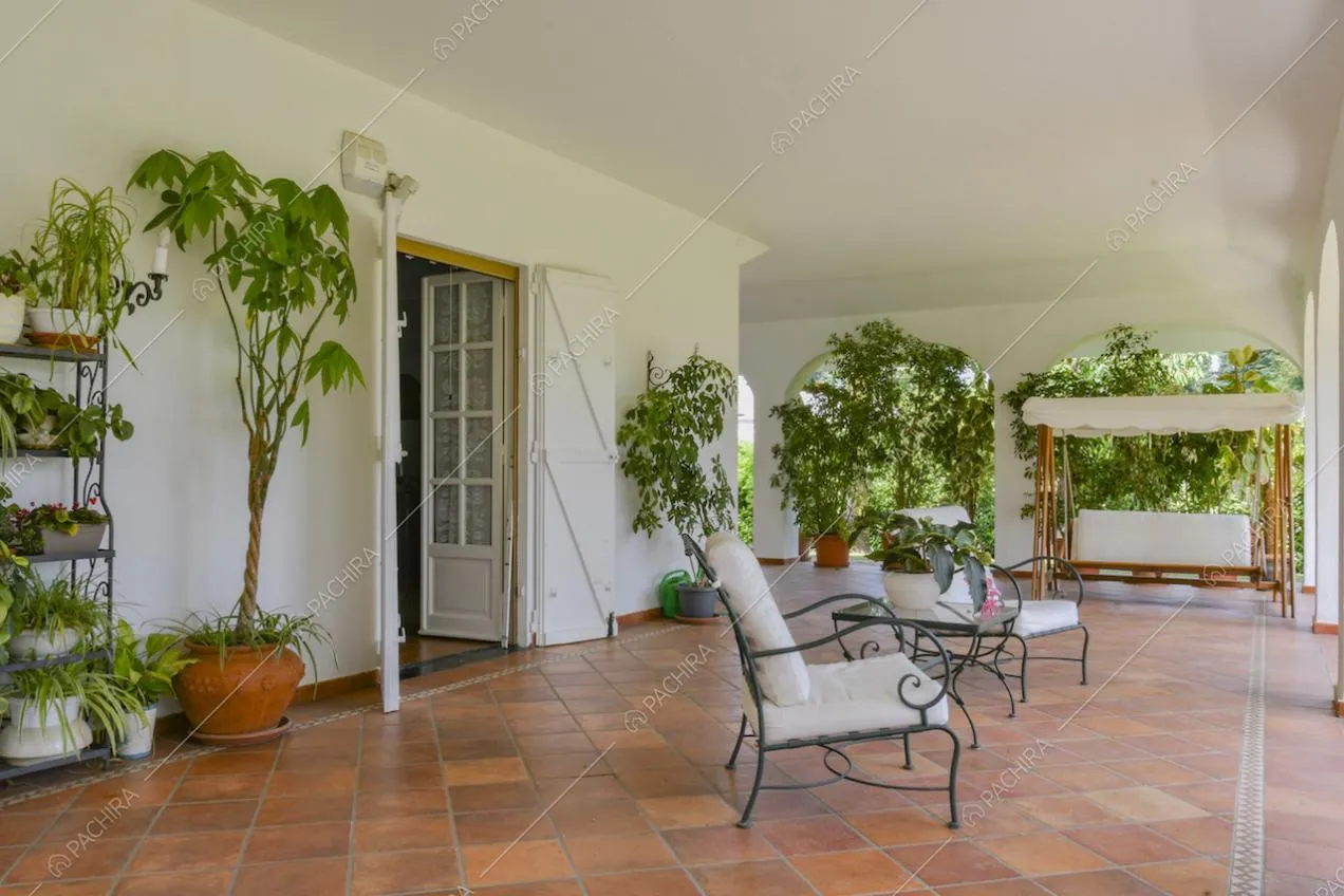 Veranda con pavimento in piastrelle e dondolo