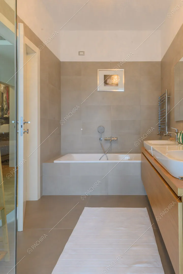 Grande bagno con piastrelle grigie e vasca