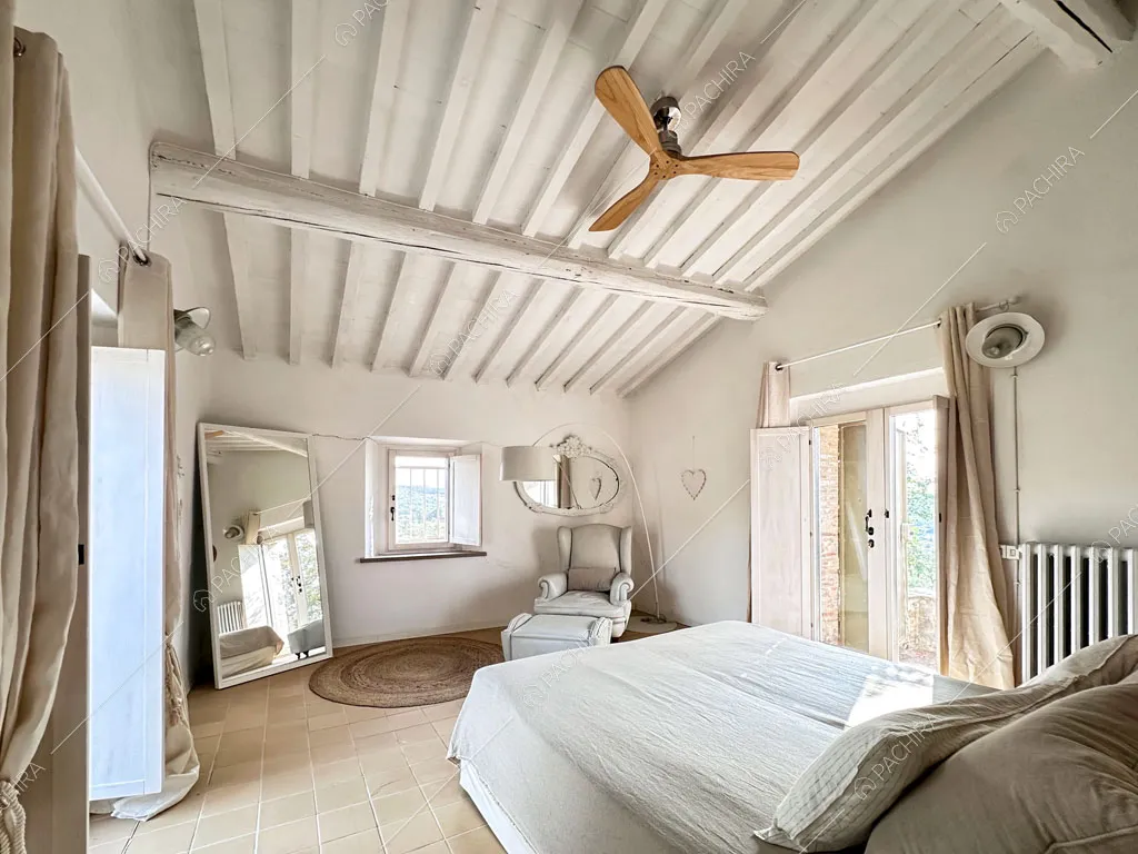 Travi bianche a vista sul soffitto nella grande camera da letto matrimoniale