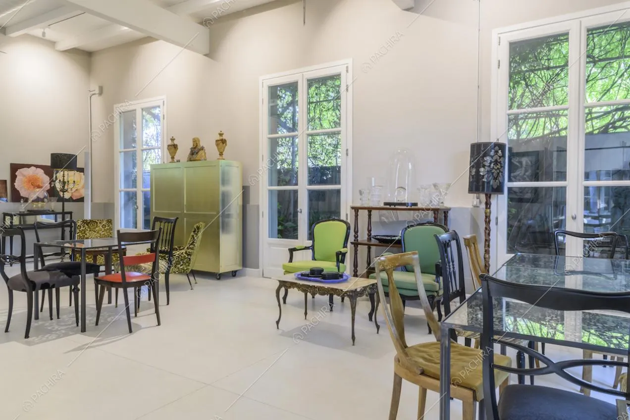 Sala con sedie di diversi stili e porte finestre bianche