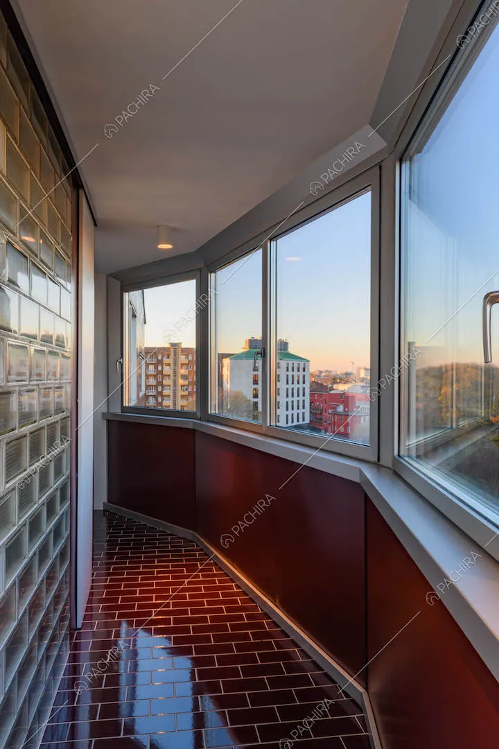 Pareti e pavimento in piastrelle rosse lucide nel corridoio con vista sullo skyline