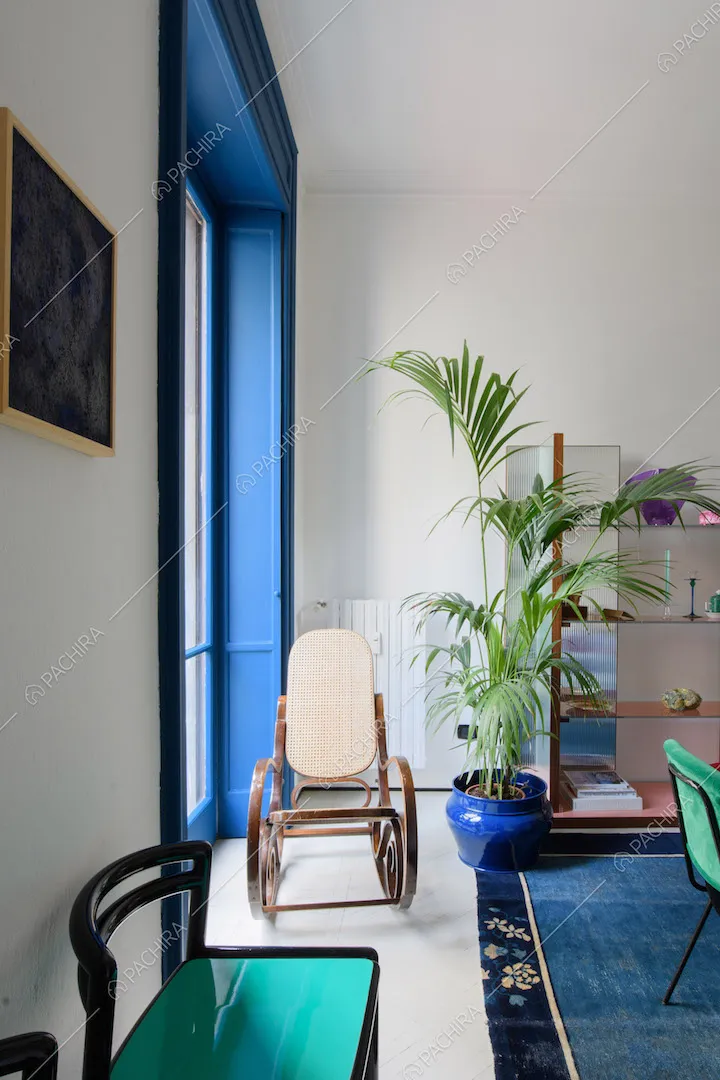 Sedie di design nello studio con pareti bianche e porta-finestra blu