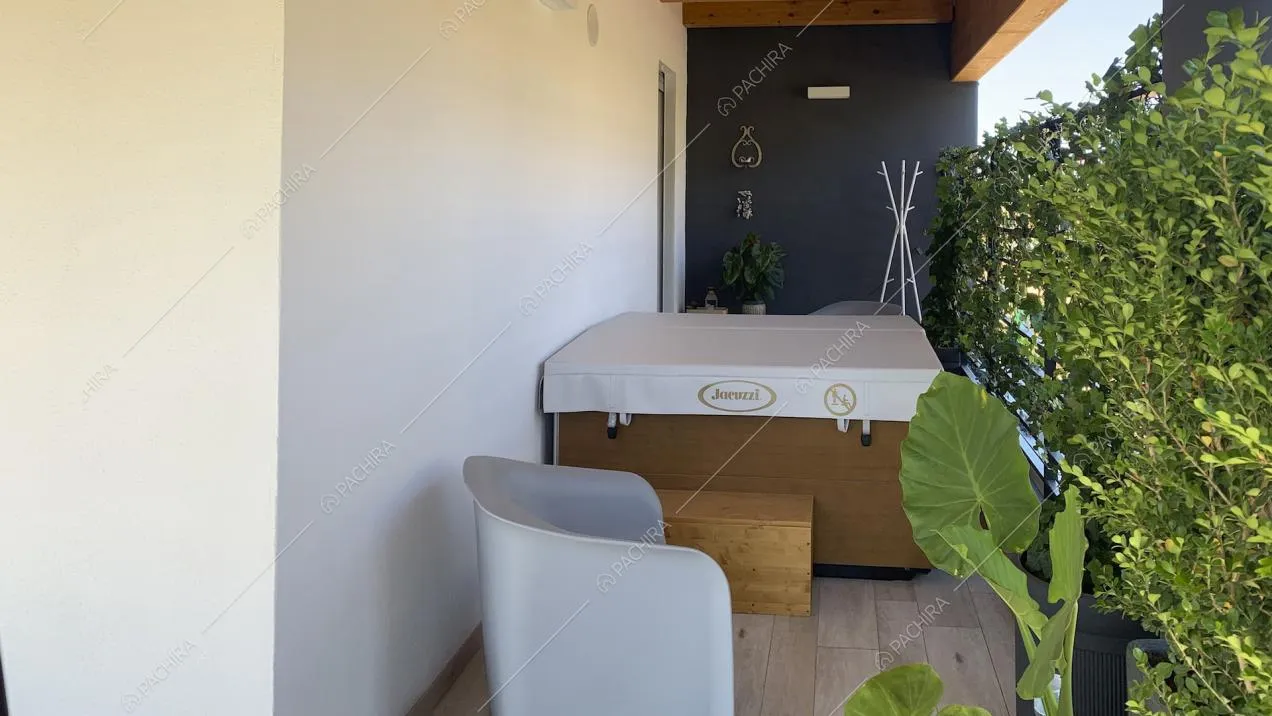 Vasca idromassaggio sul terrazzo e poltrona di design
