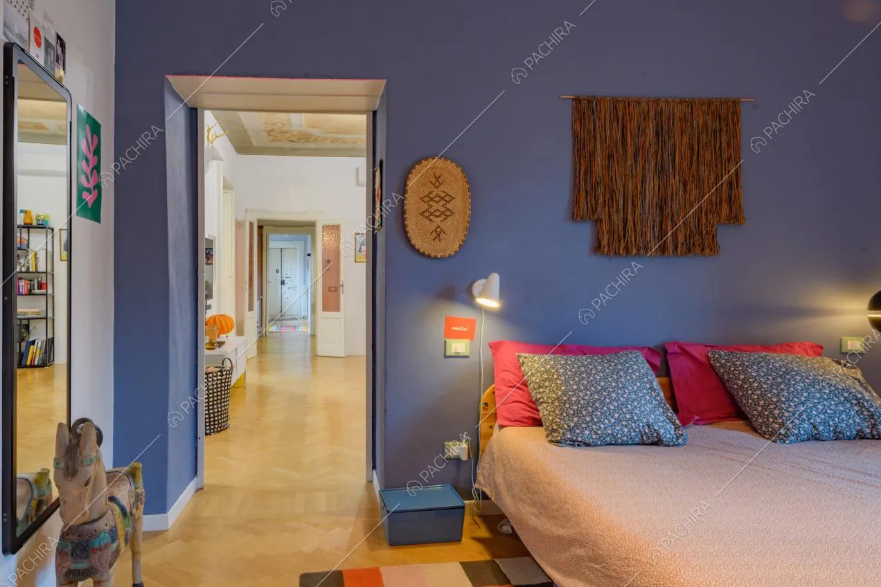 Pareti blu nella camera da letto matrimoniale con pavimento in parquet a spina di pesce