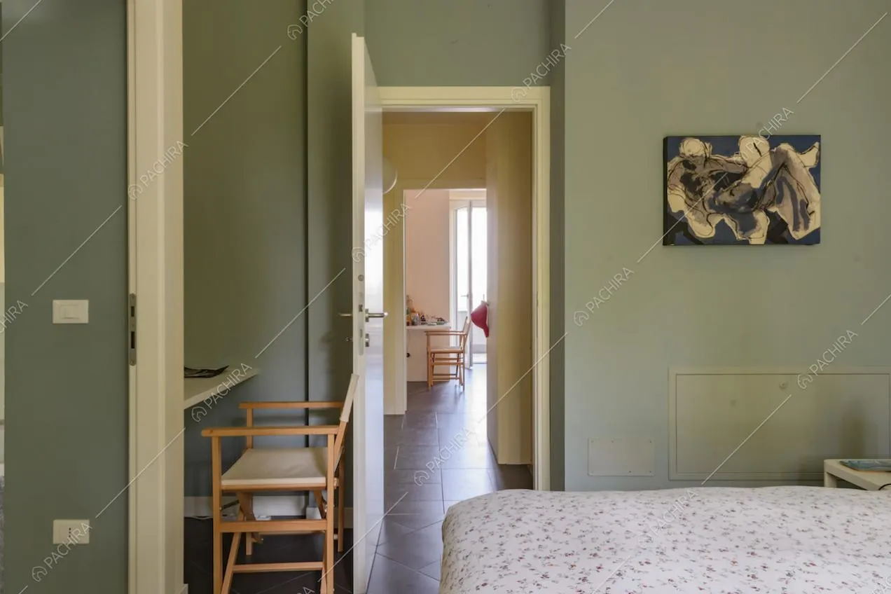 Camera da letto matrimoniale dalle pareti verdi si affaccia su un'altra stanza