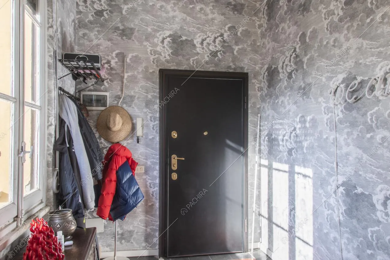 Ingresso con carta da parati, appendiabiti e mobiletto in legno scuro