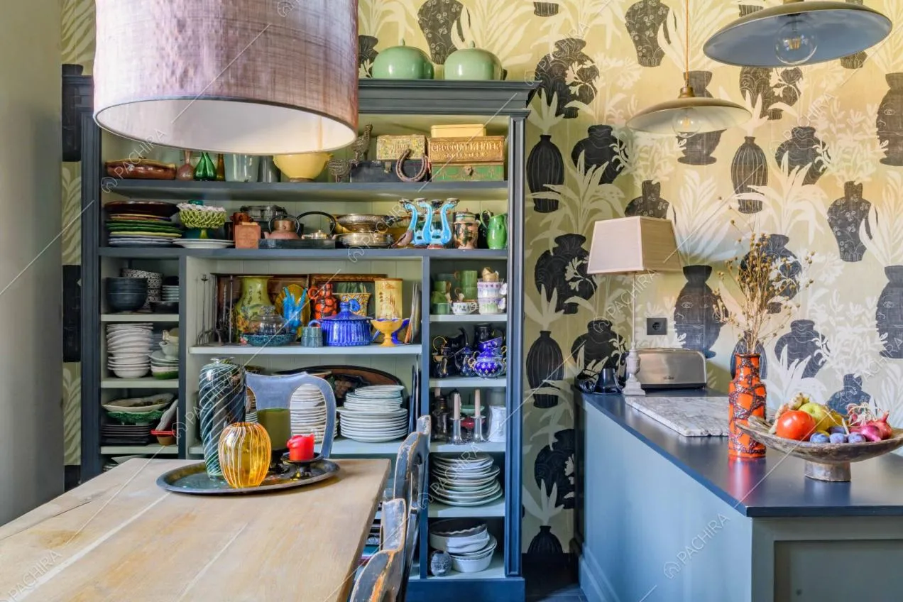 Tavolo da pranzo in legno e credenza nella cucina dalla carta da parati in stile tropicale