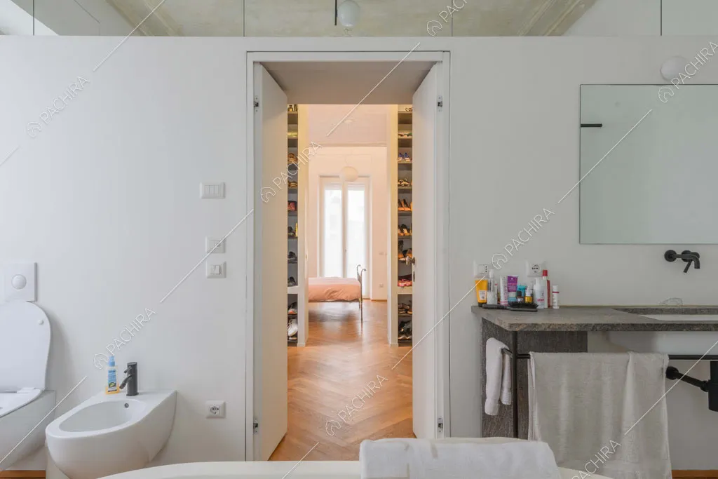 Dalla vasca del bagno privato vista sulla cabina armadio e sulla camera da letto