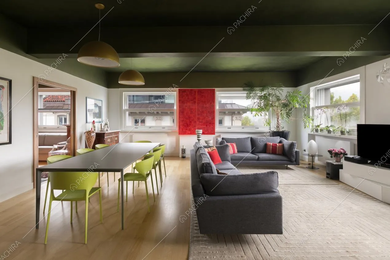 Salone con pavimento in parquet, soffitto verde e divani grigi