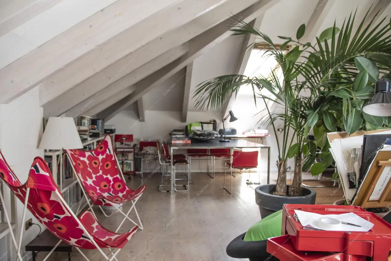 Solaio con pavimento in parquet, travi in legno a vista sul soffitto e scrivanie