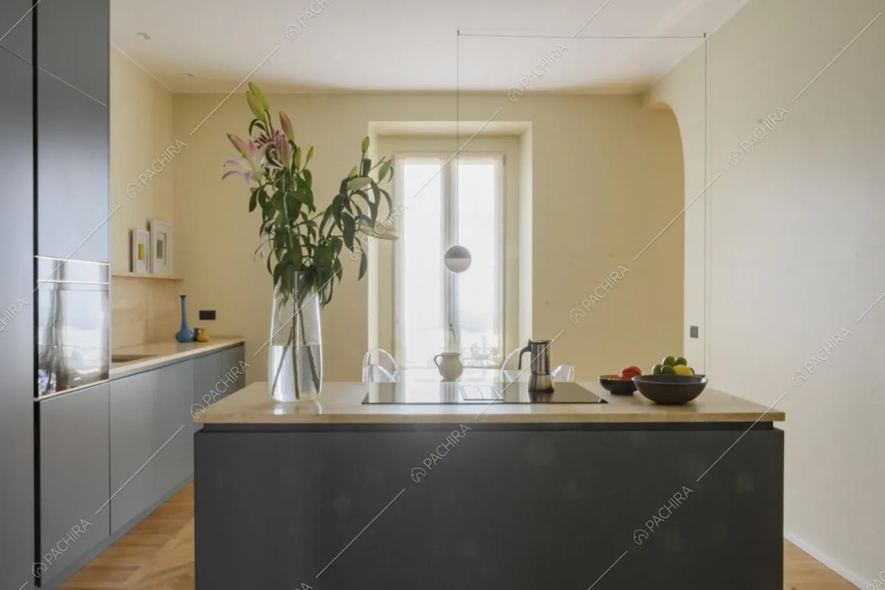 Vaso di fiori e cesti di frutta sul piano della cucina a vista