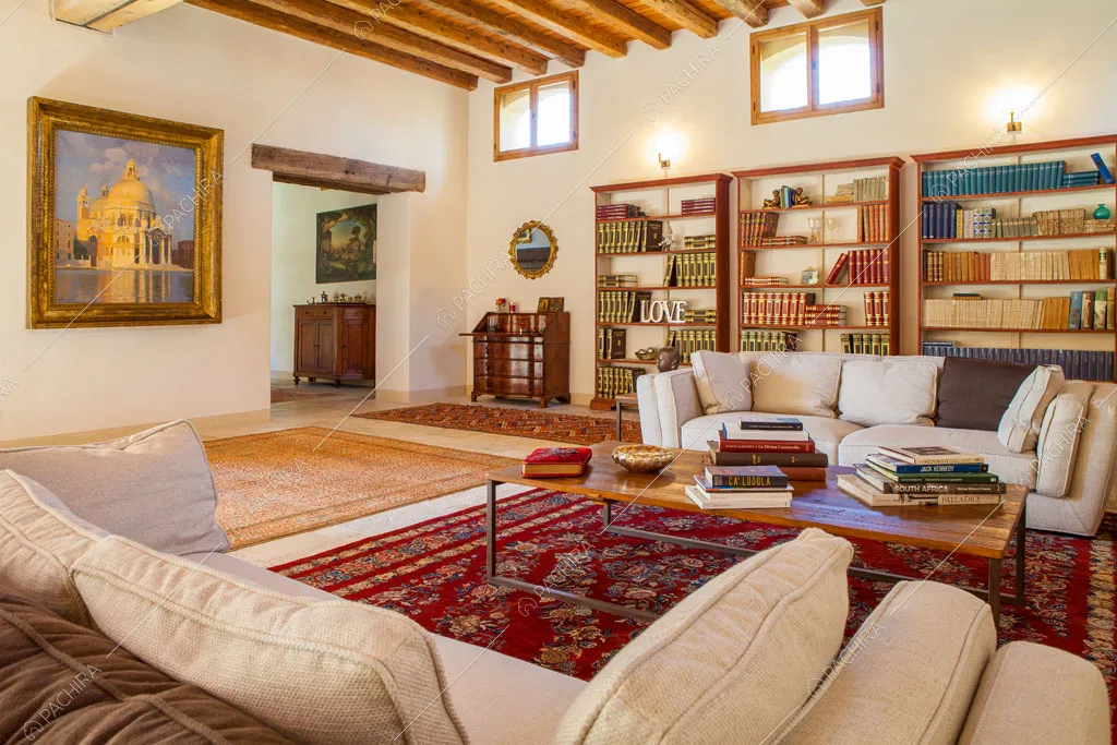 Divani bianchi, grande tappeto e librerie nella luminosa zona living