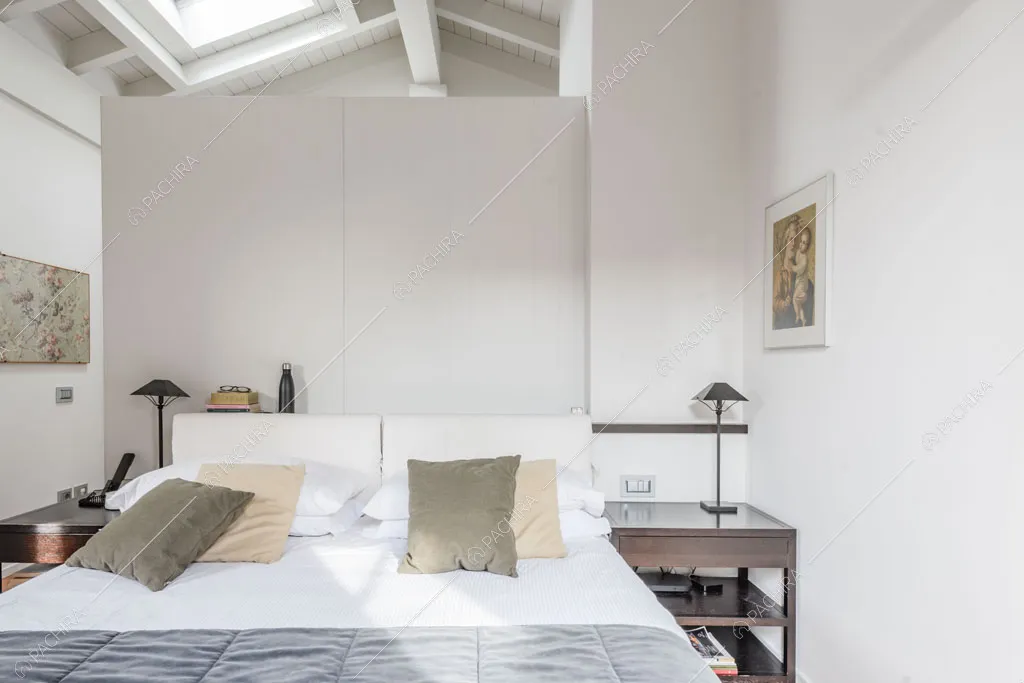 Camera da letto con travi a vista sul soffitto nella villa Roveja, location in stile contemporaneo a Como