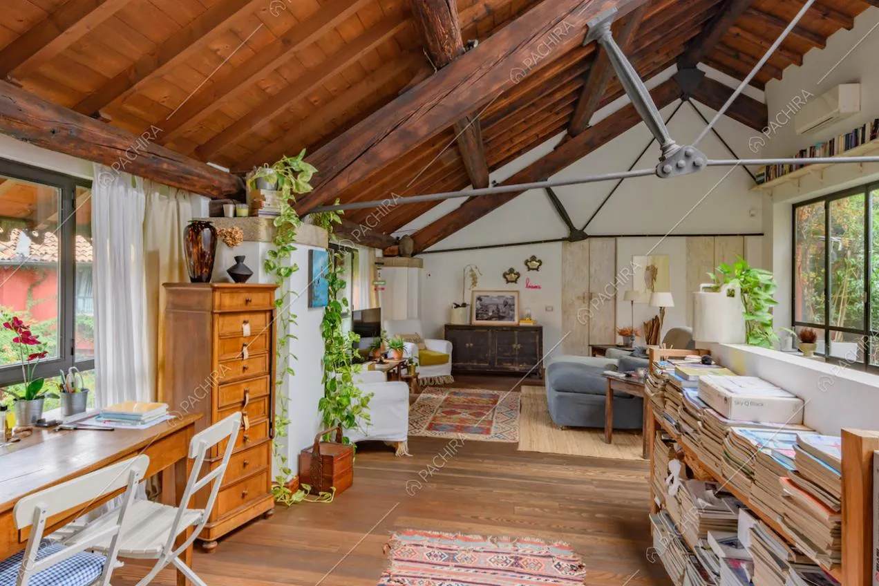 Scrivania in legno, pavimento in parquet, pareti bianche e vetrate