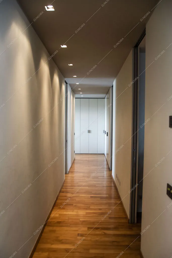 Corridoio con illuminazione a soffitto si affaccia su un armadio bianco