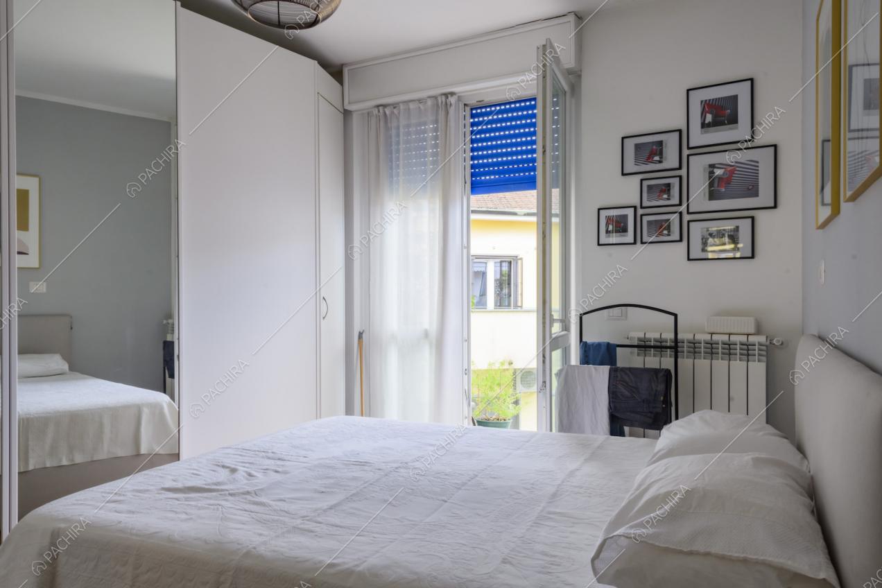 Letto matrimoniale, finestra e quadretti appesi alla parete