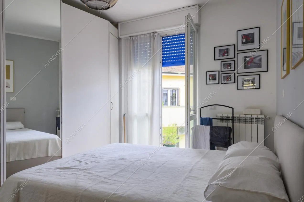 Letto matrimoniale, finestra e quadretti appesi alla parete