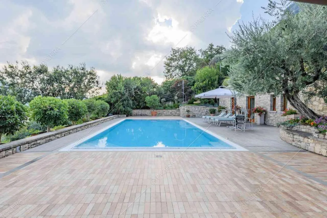 Terrazza con pavimentazione in pietra e grande piscina