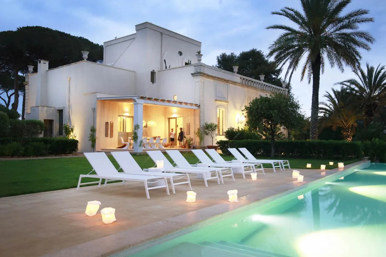 Dalla piscina nel giardino vista sulla villa dagli esterni bianchi